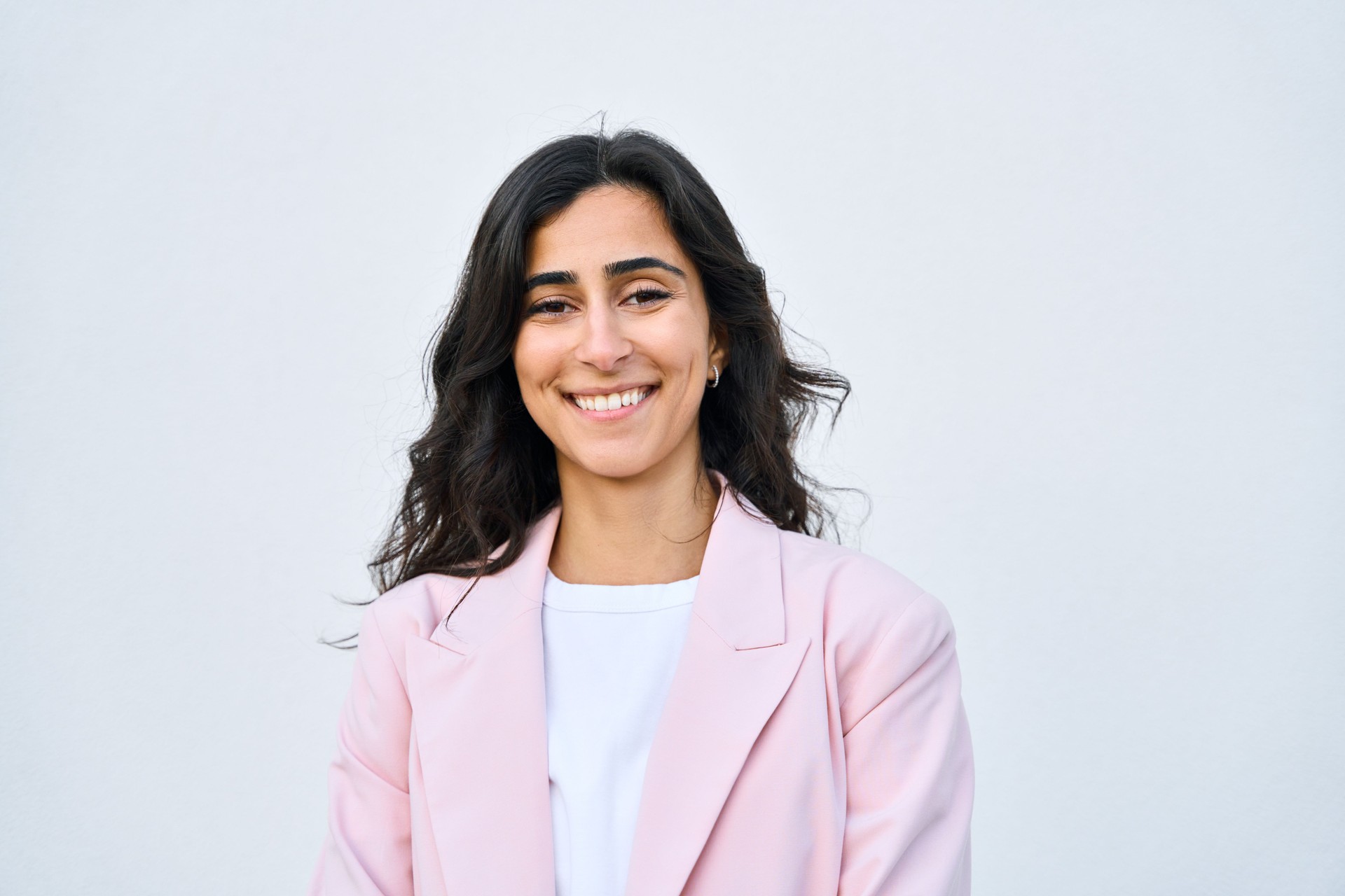 Headshot closeup portrait middle eastern Israel businesswoman, business lady standing isolated on white background. Happy smiling young successful 20s Arabian or Indian woman in suit, looking camera