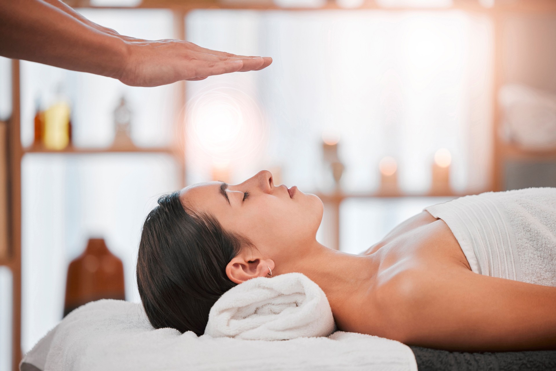 Reiki, energy and light with woman in spa for alternative medicine, spiritual and faith wellness. Health, relax and holistic therapy with hands of massage therapist for healing, peace and focus